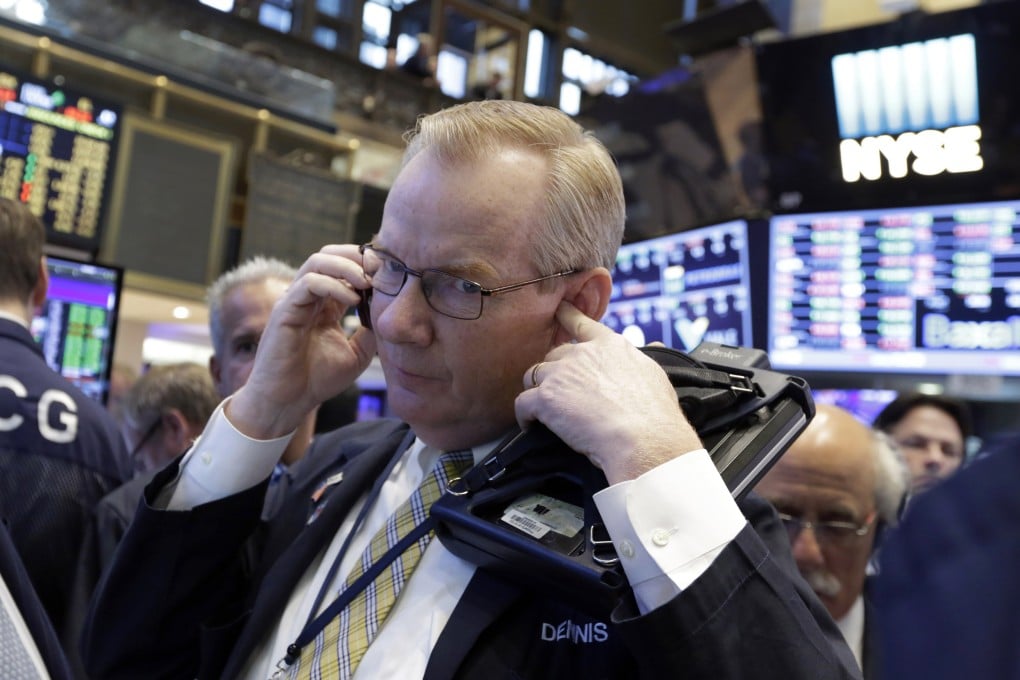 A trader on Wall Street covers his ear while listening to an order as fears of a currency war over the yuan's depreciation appear to have eased. Photo: AP