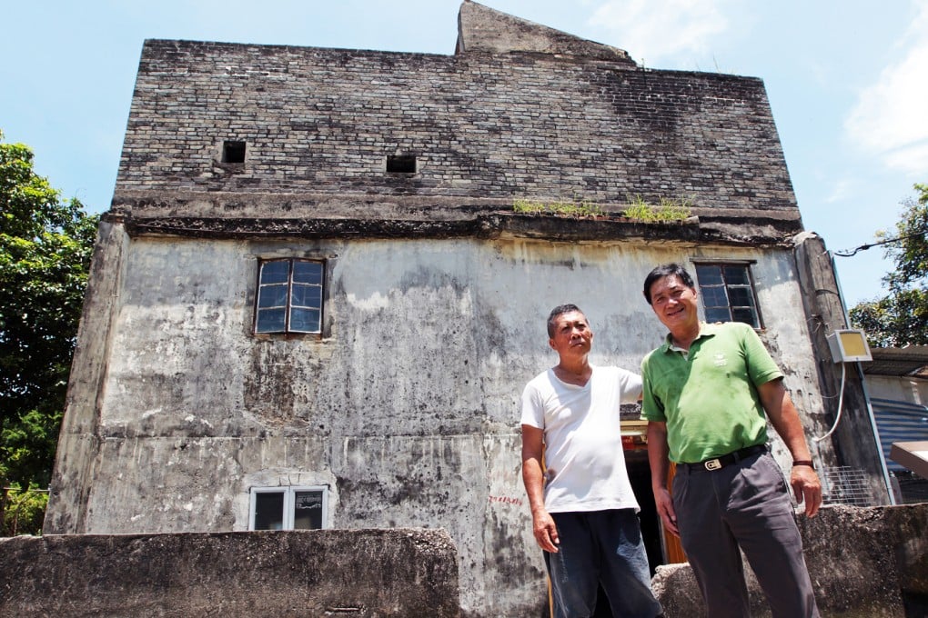 Chiu Ping-kan (left), elder brother of Chiu Ping-yin (right), poses for a photograph outside the fortified structure at No. 55 Ha Pak Nai Tsuen, Yuen Long. Photo: Bruce Yan