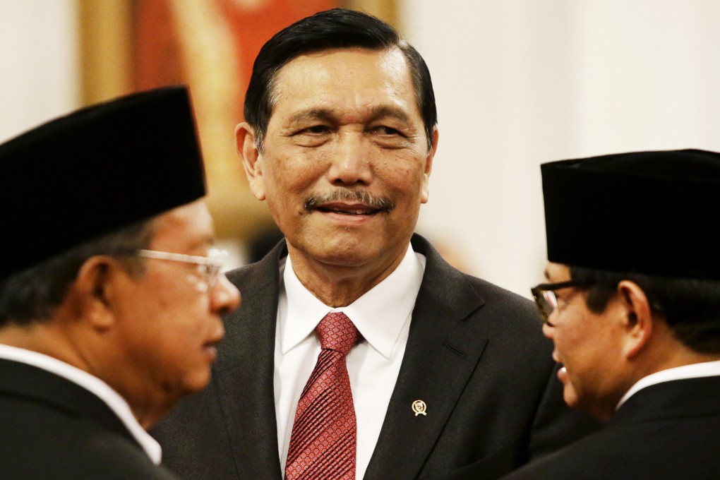 The man in the middle. Luhut Pandjaitan with Co-ordinating Minister for the Economy Darmin Nasution (left) and Cabinet Secretary Pramono Anung (right) at their inauguration at the Indonesian presidential palace on Wednesday. Photo: AP
