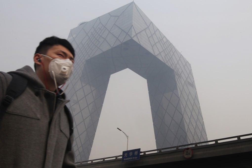 A man walks past state television's headquarters in Beijing on a polluted day in the capital. Photo: SCMP Pictures