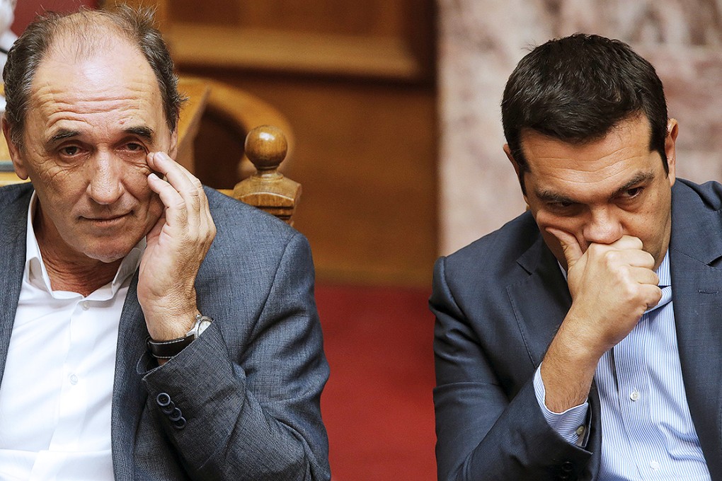 Exhausted Greek Prime Minister Tsipras and Economy Minister Stathakis attend a parliamentary session in Athens. Photo: Reuters