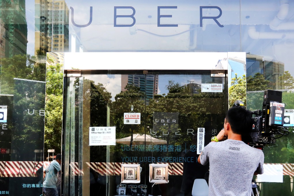 A man walks past Uber's Hong Kong office. The car-hailing app was brought to the city with the support of local authorities, but they have since turned their back on it amid a police crackdown. Photo: Edward Wong