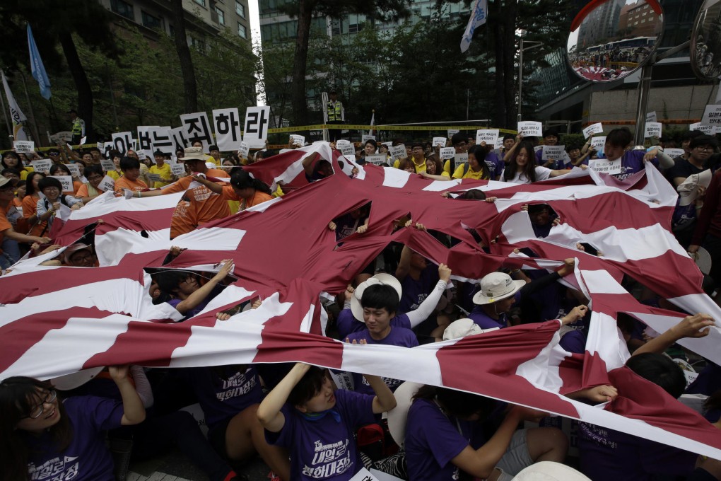 In Seoul, protesters tore up a flag. Photo: AP