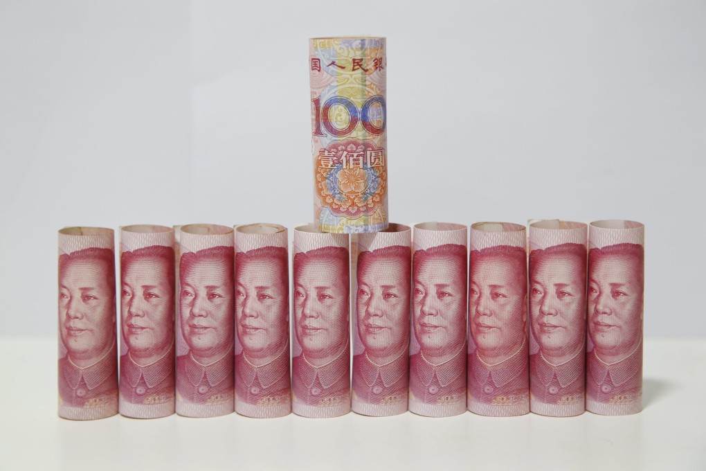 Chinese 100-yuan notes are arranged in a line like toy soldiers as the central bank set the mid-price on Monday. Photo: EPA