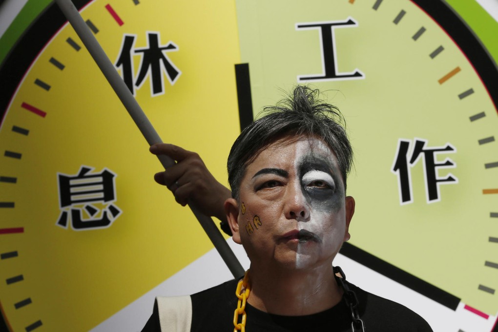A protester at a rally for workers' rights seeks to ensure standard working hours in HK.Photo: AP