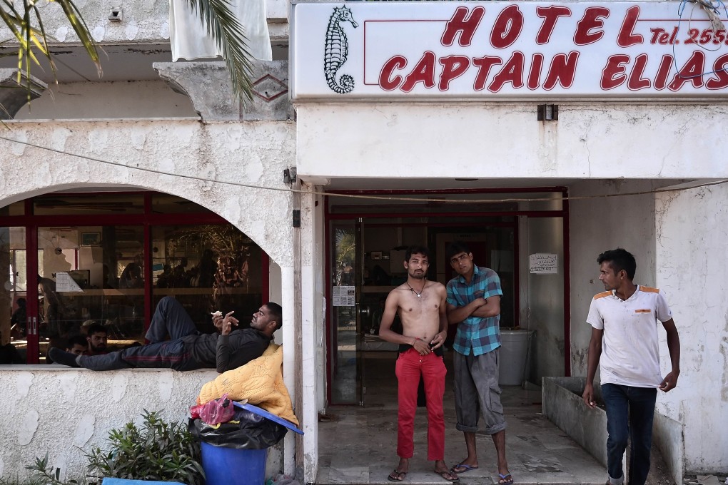 Afghan migrants stand ooutside the abandoned Captain Elias hotel on the Greek Aegean island of Kos, where migrants arriving to the island have found shelter. Photo: AFP