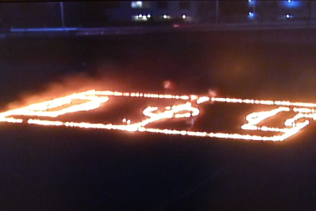 A still from performance art group Chim Pom's "Feelin’ like the guys make me hot 01", in which they set various objects on fire.