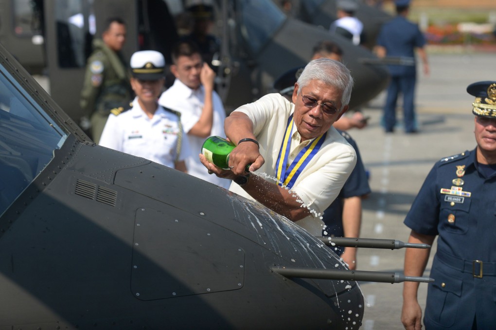 Philippines defence secretary Voltaire Gazmin pours champagne over the nose of a Bell 412 helicopter in a christening ceremony. Photo: AFP