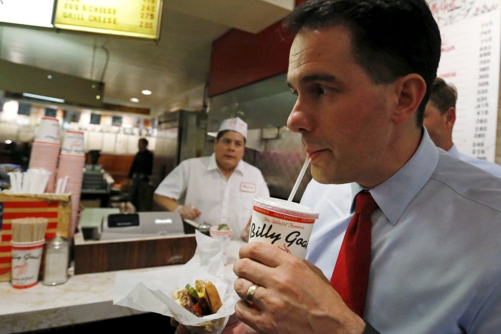 US Republican presidential candidate Scott Walker eats his food order during a campaign stop at the Billy Goat Tavern in Chicago. Photo: Reuters
