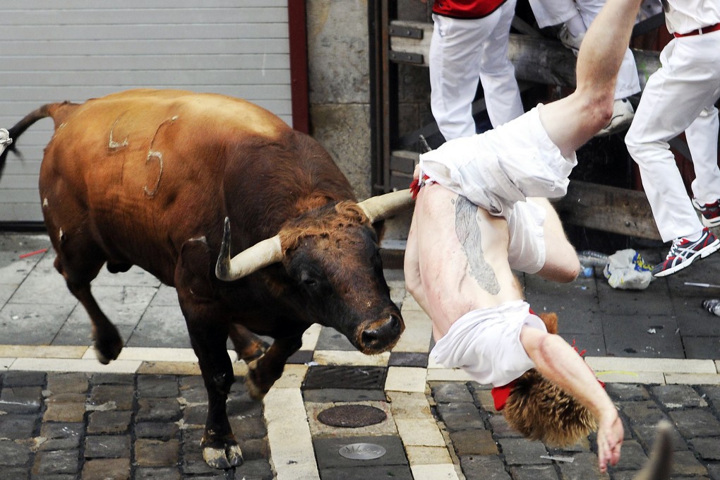 A Jandilla bull charges a participant during the first "encierro" (bull-run) of the San Fermin Festival in Pamplona, northern Spain, in July.  Photo: AFP