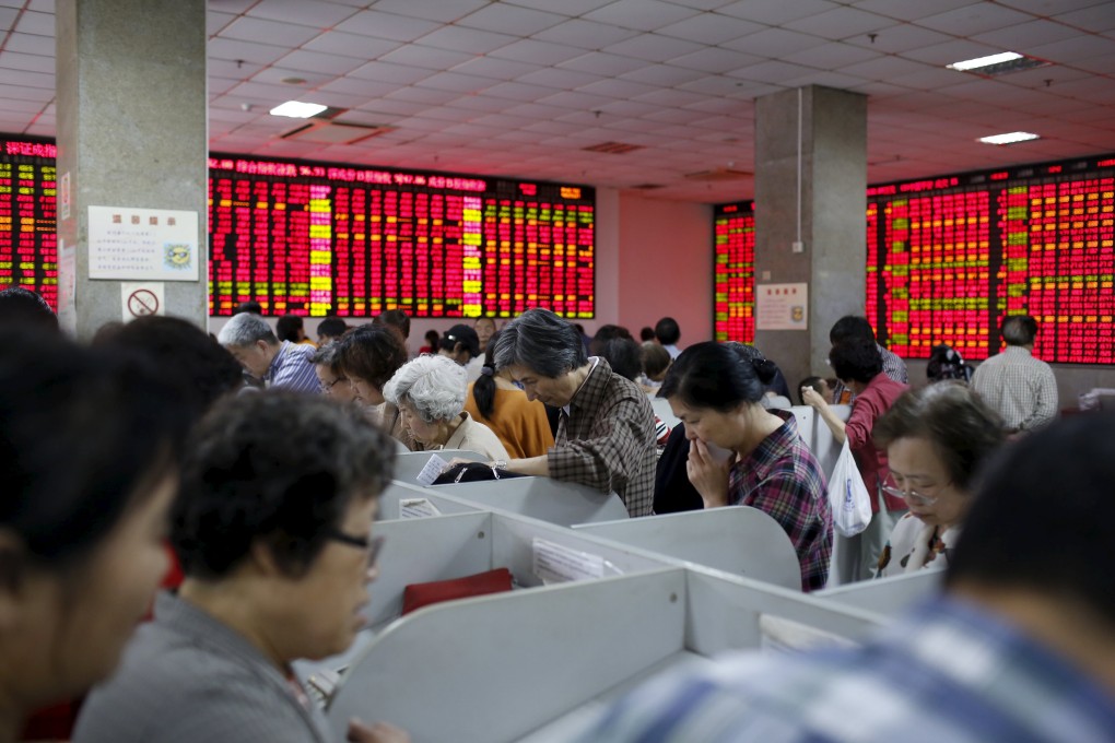 Scores of Chinese investors pore over their computer screens at a brokerage house in Shanghai. Photo: Reuters