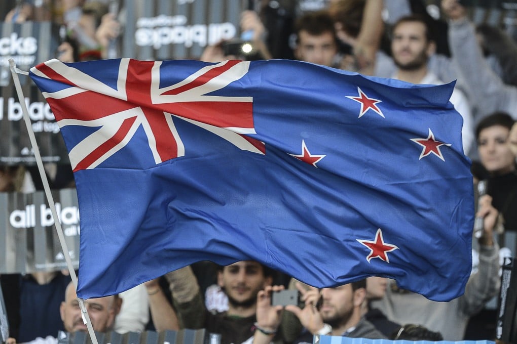 Rugby fans wave a New Zealand flag at an All Blacks match against Italy.