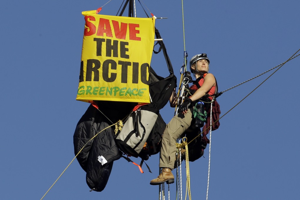 An activist hangs from a bridge as part of a protest to block the Royal Dutch Shell PLC icebreaker Fennica from leaving for Alaska in Portland. Photo: AP