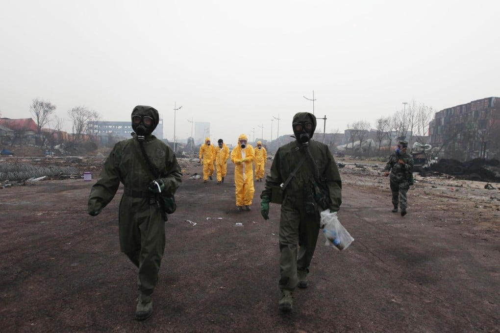 A team of specialists decked in protective gear and breathing masks enter the core of the explosion site in the port city of Tianjin on Wednesday to conduct investigations and clean up the scene. Photo: Xinhua