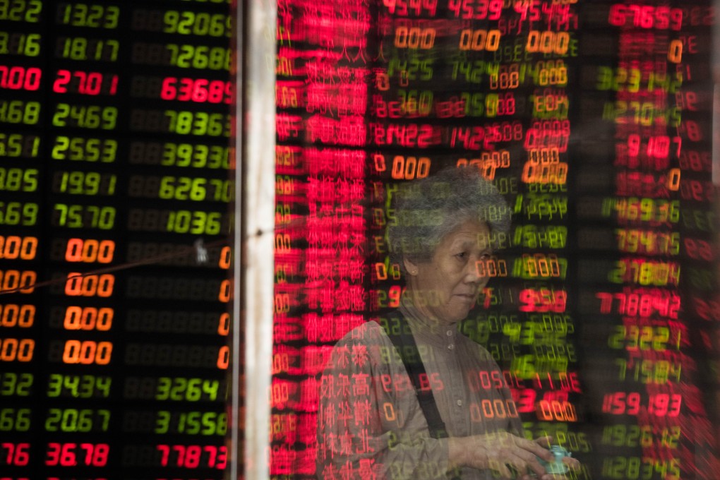 The image of a Chinese investor is seen against the backdrop of volatile stock prices in the country's equity markets. Photo: AFP