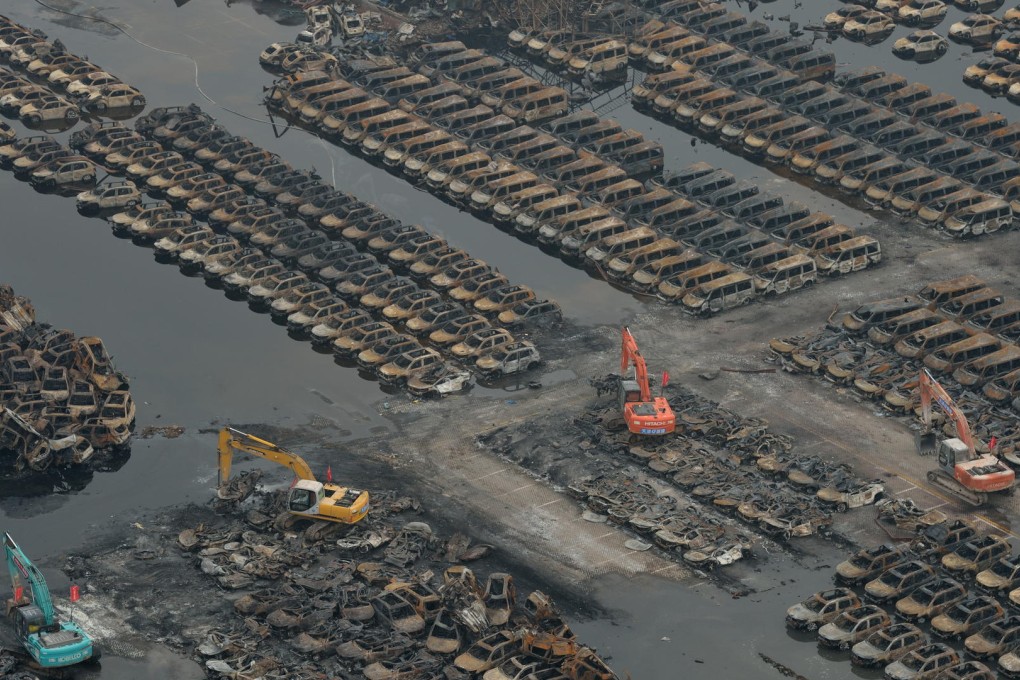 Clean-up workers operate machinery to clear thousands of imported cars damaged by last Wednesday's massive explosions in the port city of Tianjin. Photo: Xinhua