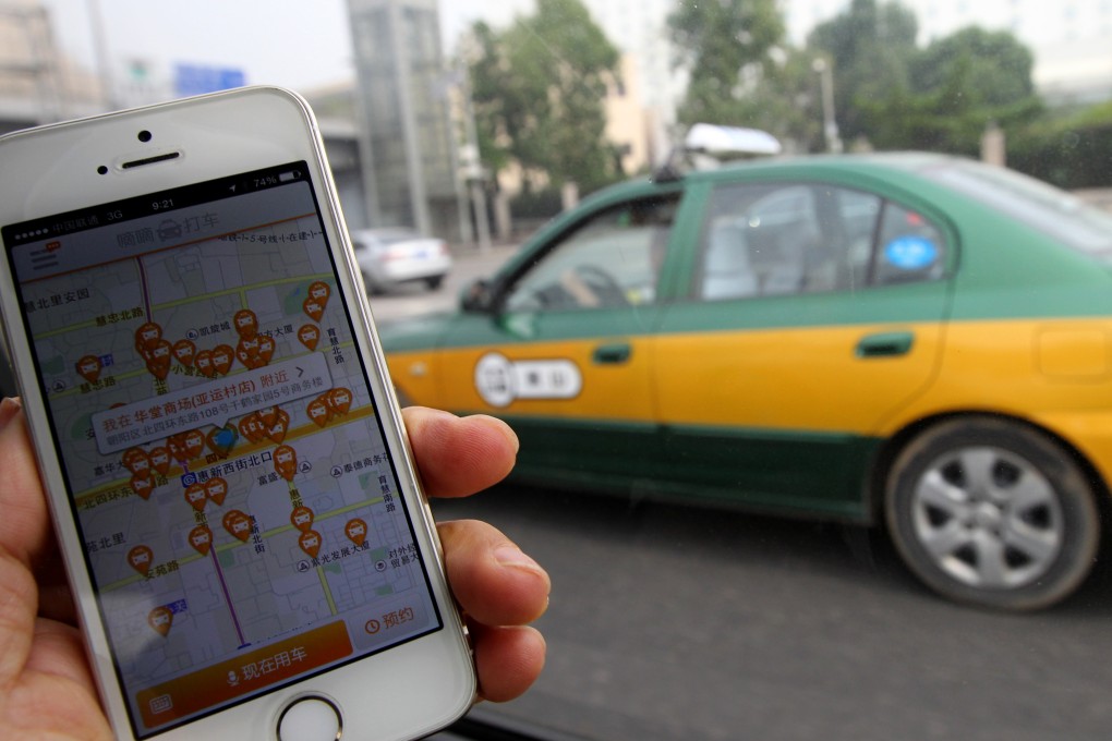 The Didi Dache app is pictured with a taxi passing by in Beijing last year, before China's leading car-hailing apps merged this year to create Didi Kuaidi. Photo: Simon Song