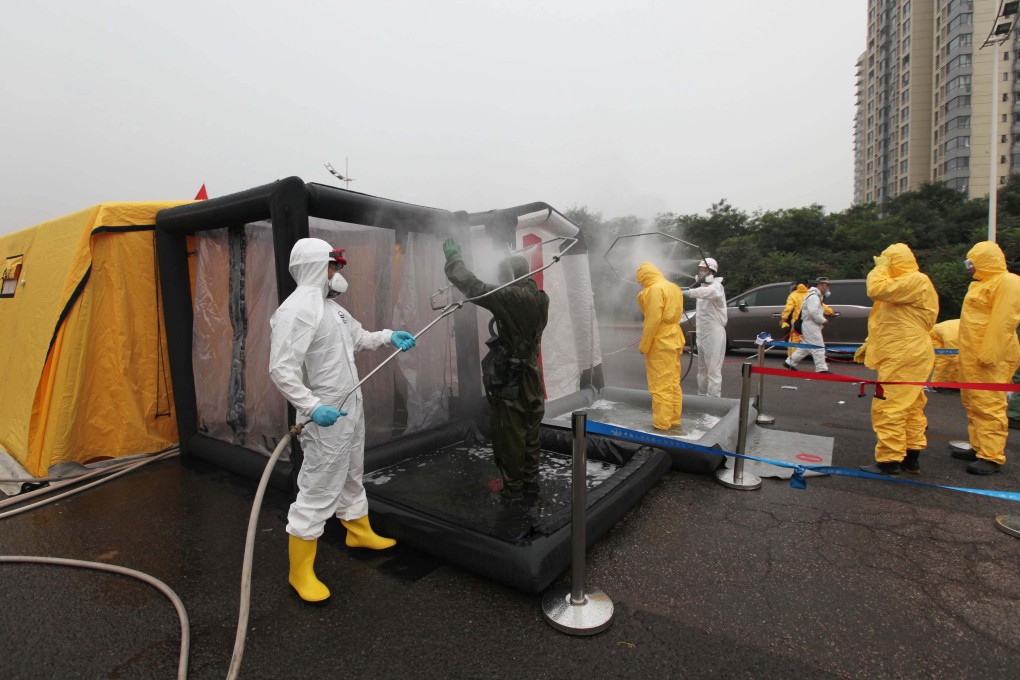 Relief workers' protective clothing is sterilised while working on the clean-up operation at the blasts site in Tianjin. Photo: Xinhua