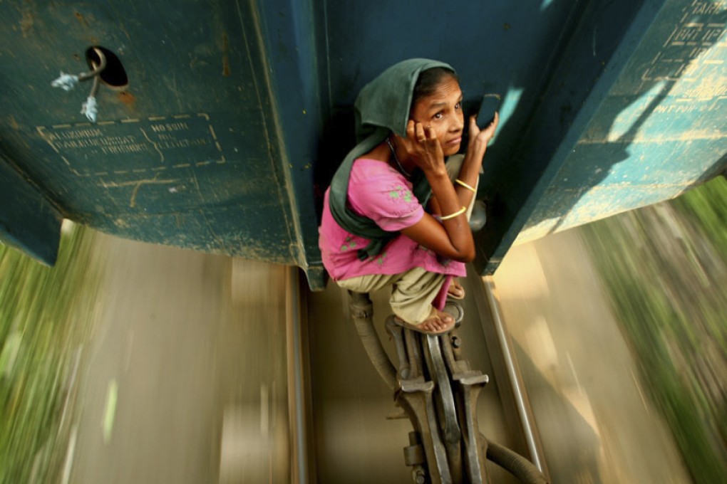 A woman hitches a ride between two train carriages in Bangladesh, by G.M.B. Akash, overall winner of the 2009 Travel Photographer of the Year award.