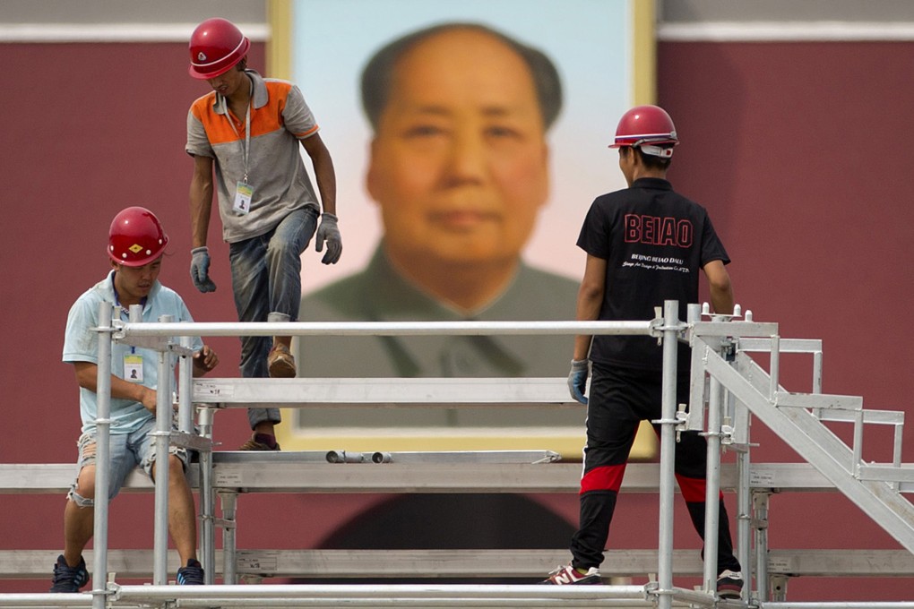 Workers prepare seating in front of a portrait of Mao Zedong in Tiananmen Square ahead of the parade on September 3. Photo: AP