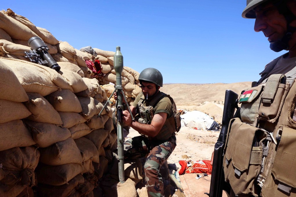 Iraqi Kurdish Peshmerga fighters prepare a mortar shell near Mosul. Photo: AFP