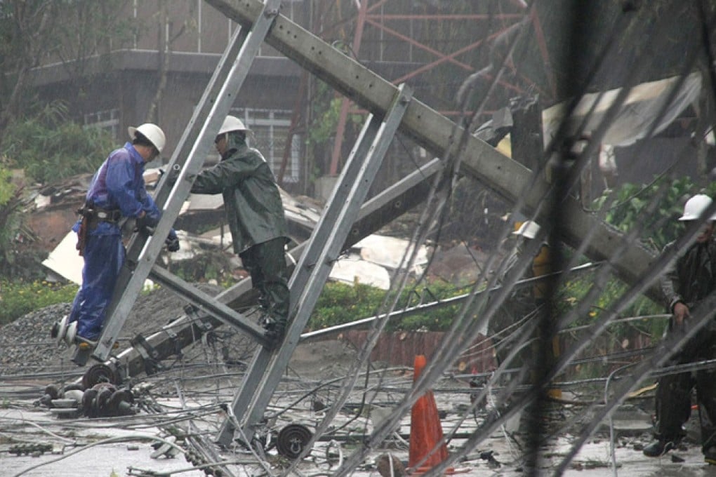 Workers clear a road with fallen electric posts after Typhoon Goni battered Baguio city in the northern Philippines. Photo: Reuters