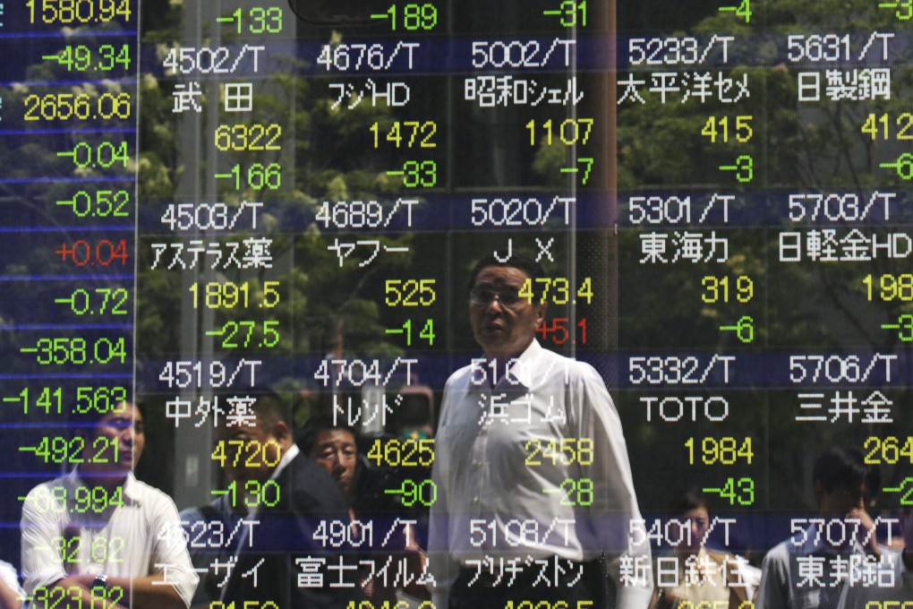 A businessman is watching the Tokyo stock index as investors in Tokyo focus on the release of US GDP figures this week. Photo: EPA