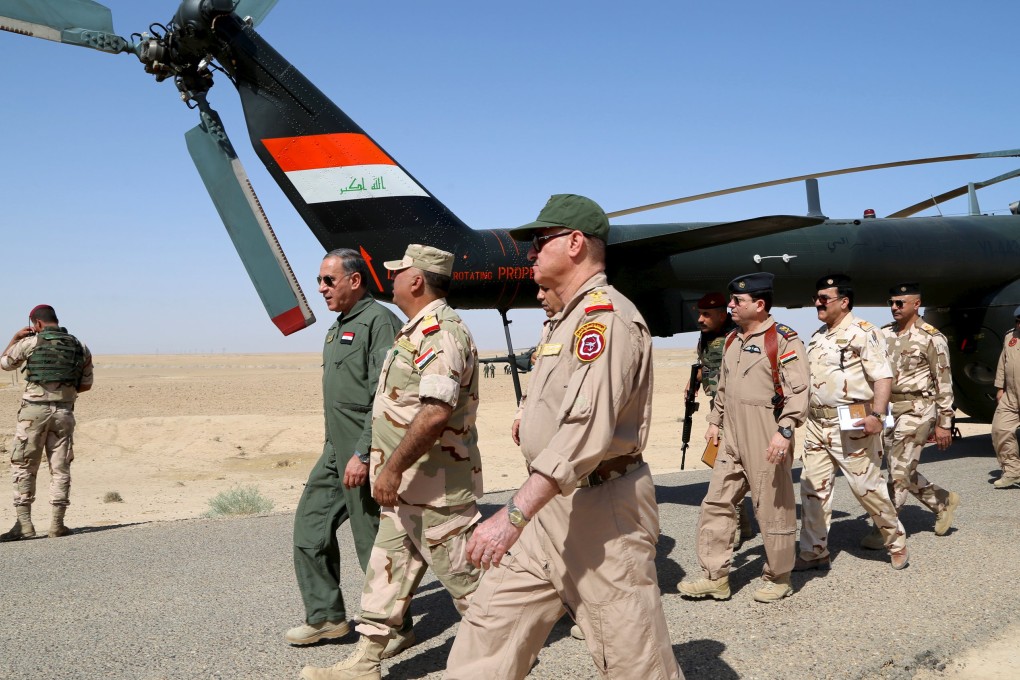 Iraqi Defence Minister Khaled al-Obeidi walks with officers during his visit to an Iraqi army on the outskirts of Anbar province. Photo: reuters