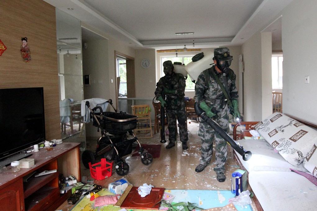 Military specialists in handling nuclear and biochemical materials decontaminate at a residential community near the core area of the warehouse explosion site in Tianjin. Photo: Xinhua