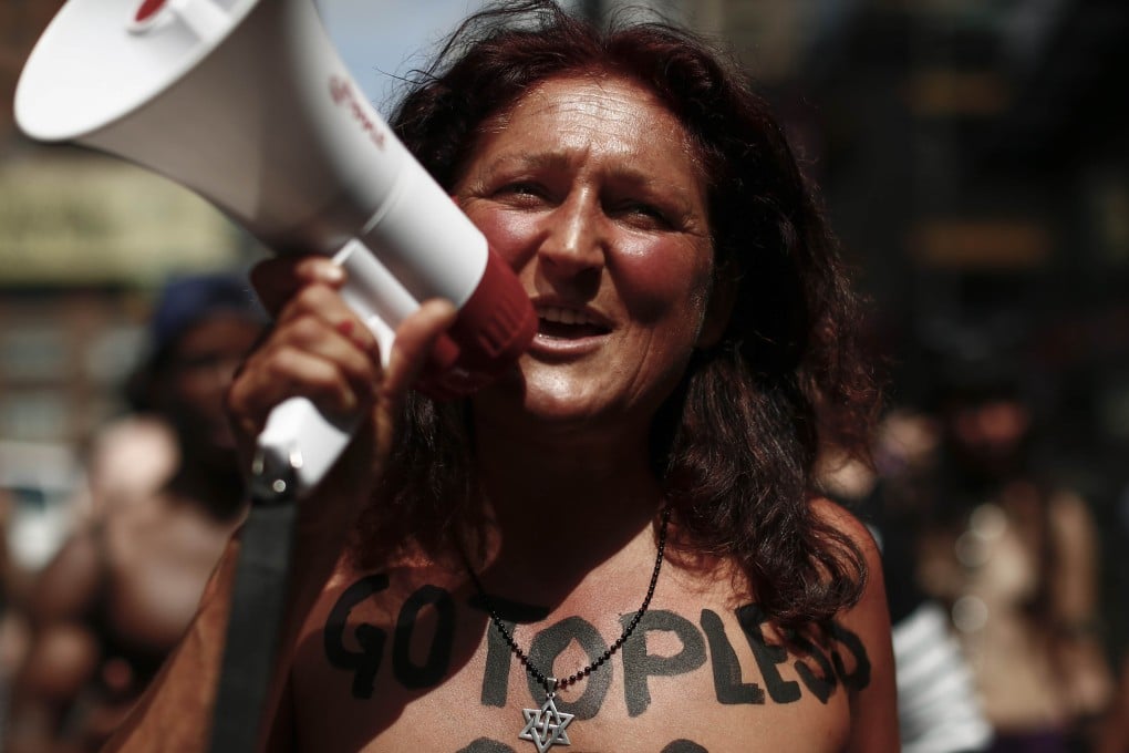 A woman uses a megaphone as she bares her breasts in the GoTopless pride parade in Manhattan. Photo: AFP
