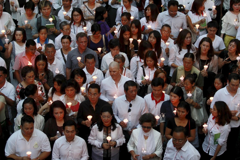 People light candles for victims during a march to the Erawan shrine in Bangkok. Photo: Reuters