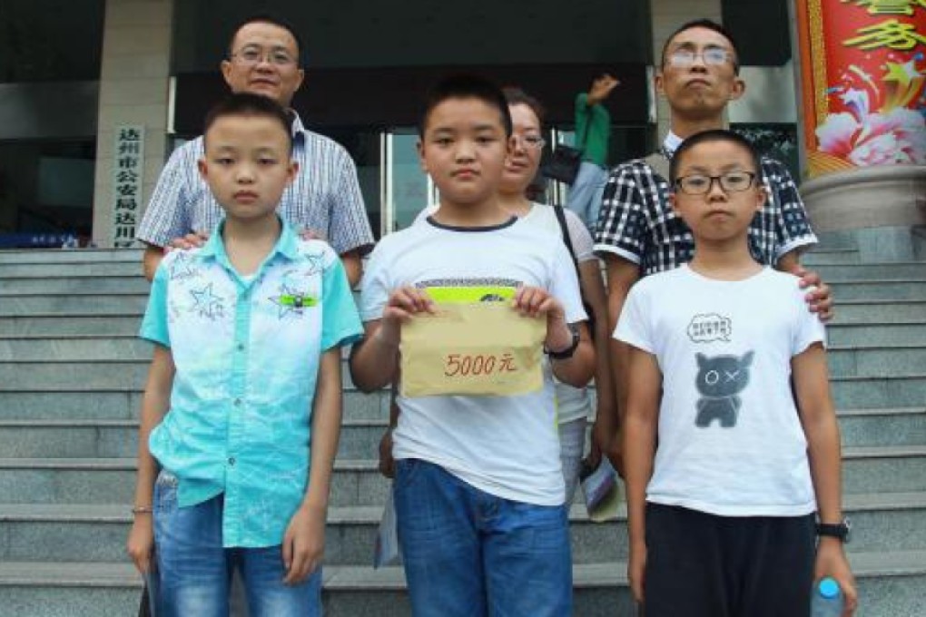 All's well that ends well: the three boys, pictured with their parents, were honoured in Dazhou for their good deed. Photo: Guancha.com