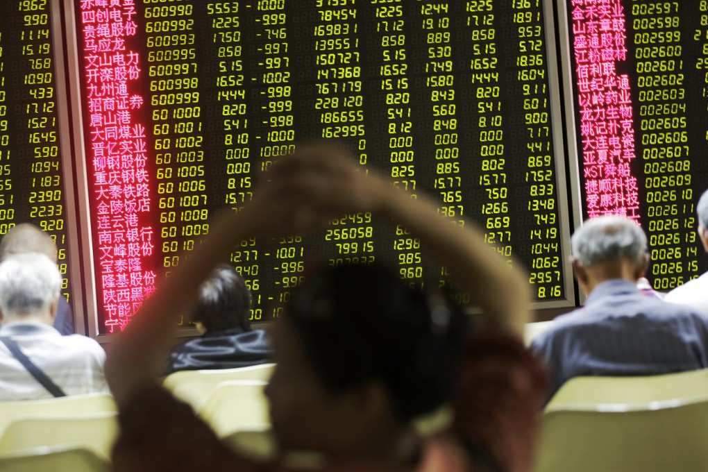 Investors look at screens showing stock market movements at a securities company in Beijing on Tuesday. Photo: EPA