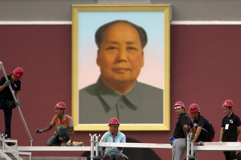 Workers install temporary seating at Tiananmen Square near the large portrait of Chairman Mao Zedong on Tiananmen Gate in Beijing. Photo: AP