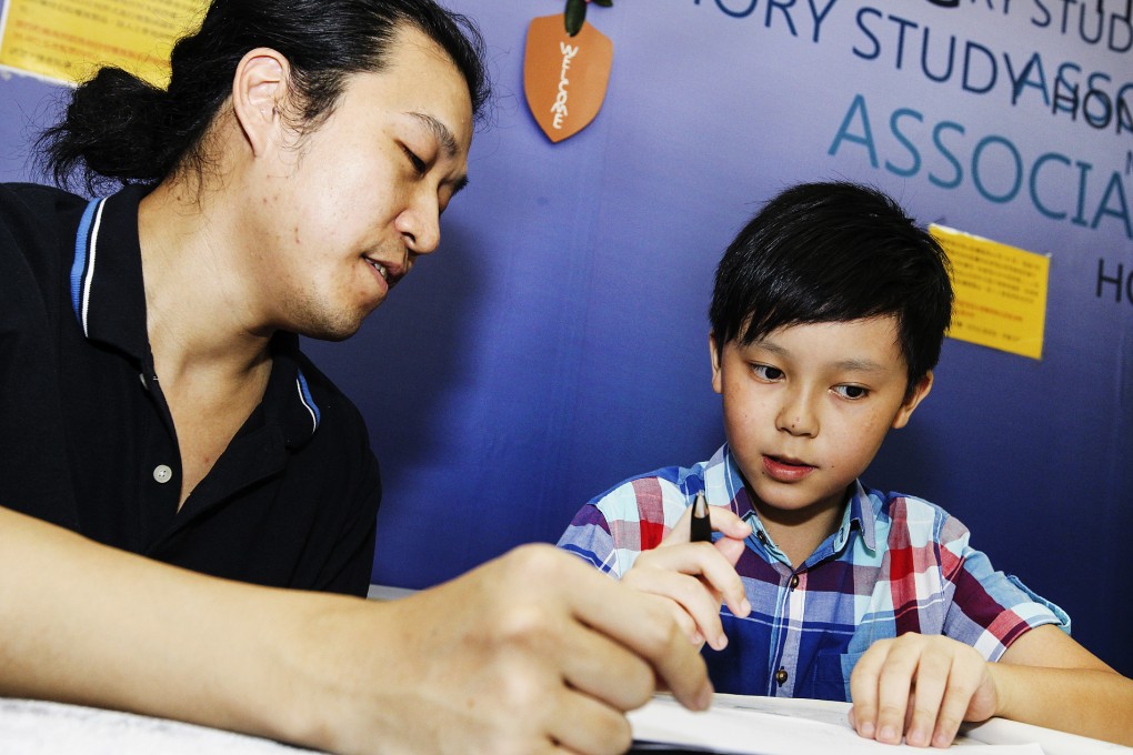 Hong Kong Memory Study Association executive director Lam Kin-tung (left) gives Nathan Lee a lesson. Photo: Franke Tsang