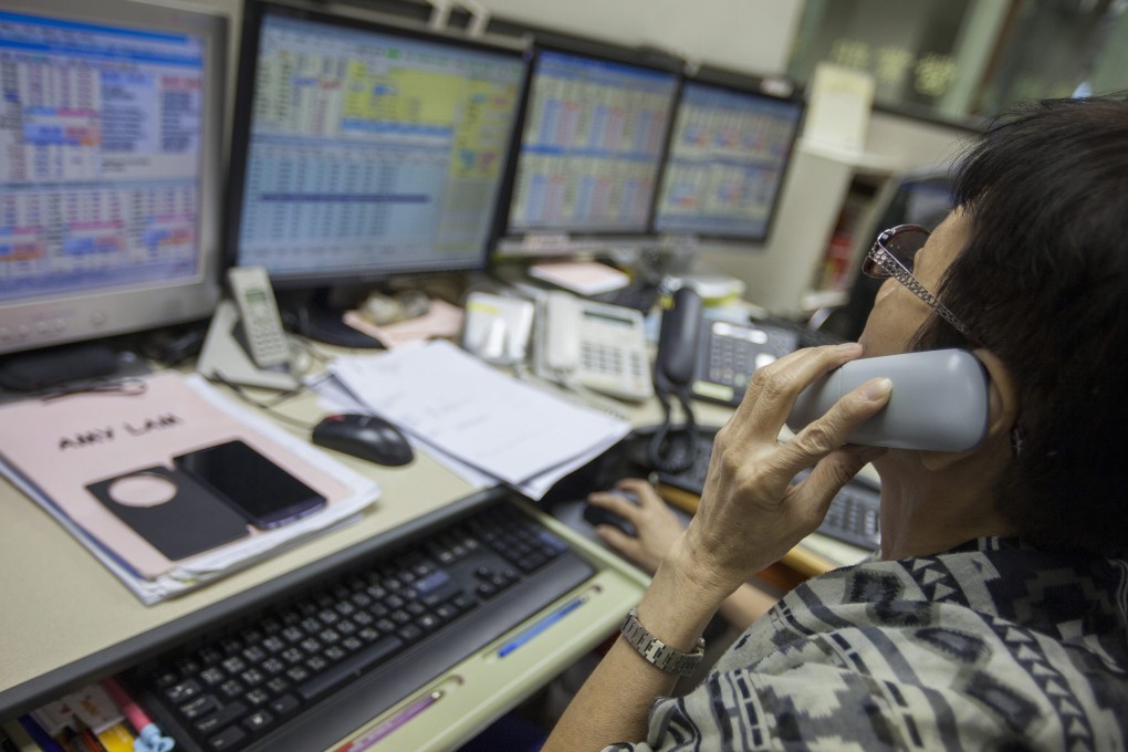 A stock broker works the phones in Hong Kong as the market recovers after getting pounded earlier in the week, with the Hang Seng Index climbing after Wall Street rallied overnight. Photo: EPA