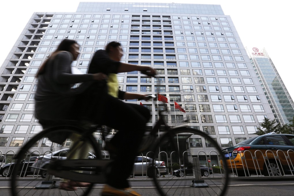 Cyclists pass the China Securities Regulatory Commission building in Beijing. The regulator is investigating several securities companies. Photo: EPA