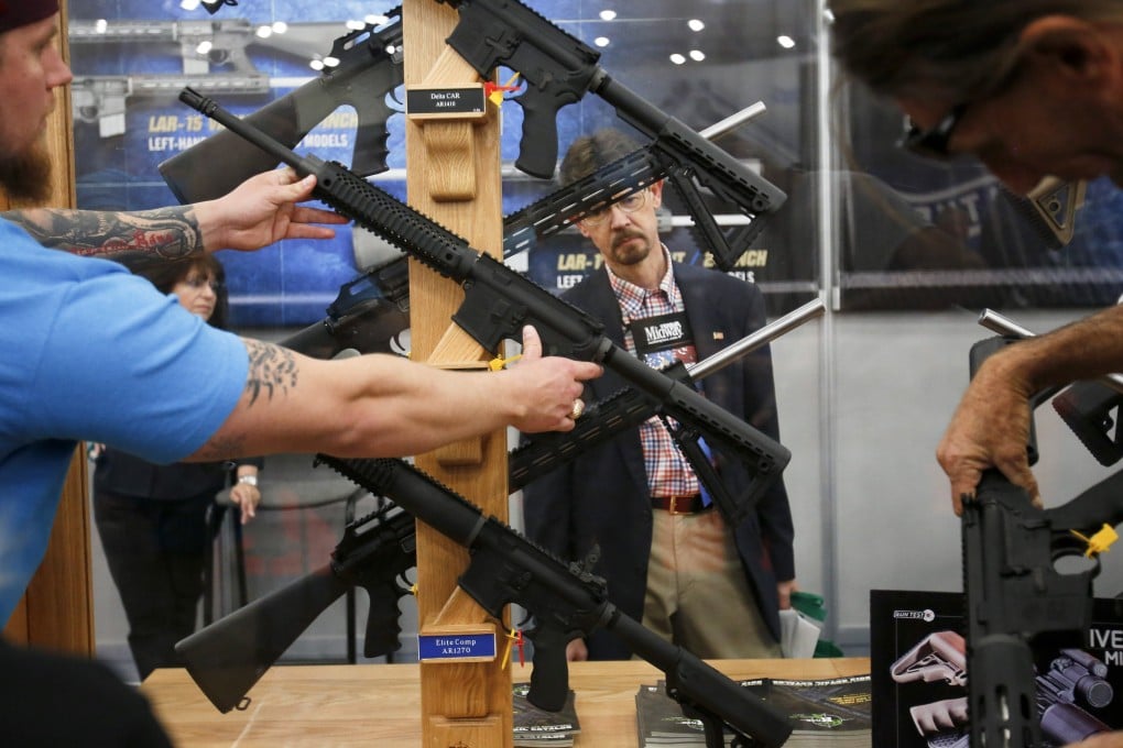 Attendees look at AR-15 style rifles during at 2013 National Rifle Association annual convention in Houston.