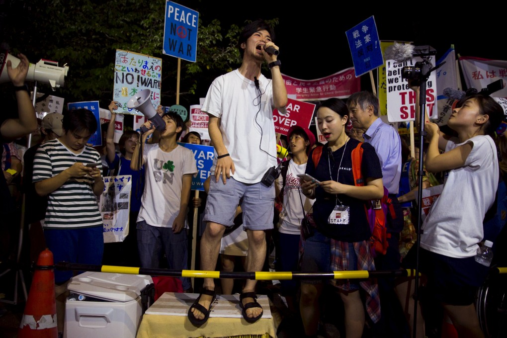 Aki Okuda, founding member of the protest group SEALDs, shouts slogans during a protest outside parliament in Tokyo. Photo: Reuters