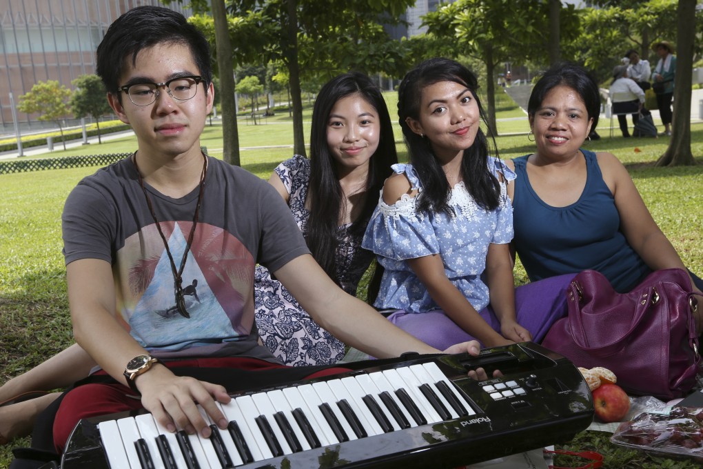 Jonathan Wong, concert organiser and member of We Care; and Vicky Kung Wing-kei, co-founder of We Care, pose with Filipino performers Dimple and mother Vilma at Tamar Park. Photo: Nora Tam