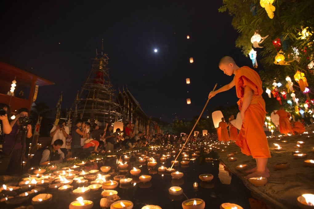 Thai Buddhist monks arrange candles after a blessing ceremony during the Loy Krathong Festival at a temple in Chiang Mai, Thailand. Photo: AP