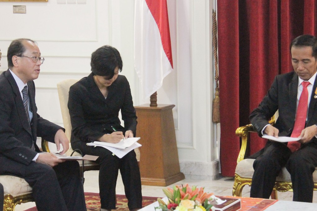 Hiroto Izumi, left special adviser to Japanese Prime Minister Shinzo Abe, holds talks with Indonesian President Joko "Jokowi" Widodo, right. Japan submitted new proposals to Indonesia on the train project this week. Kyodo.