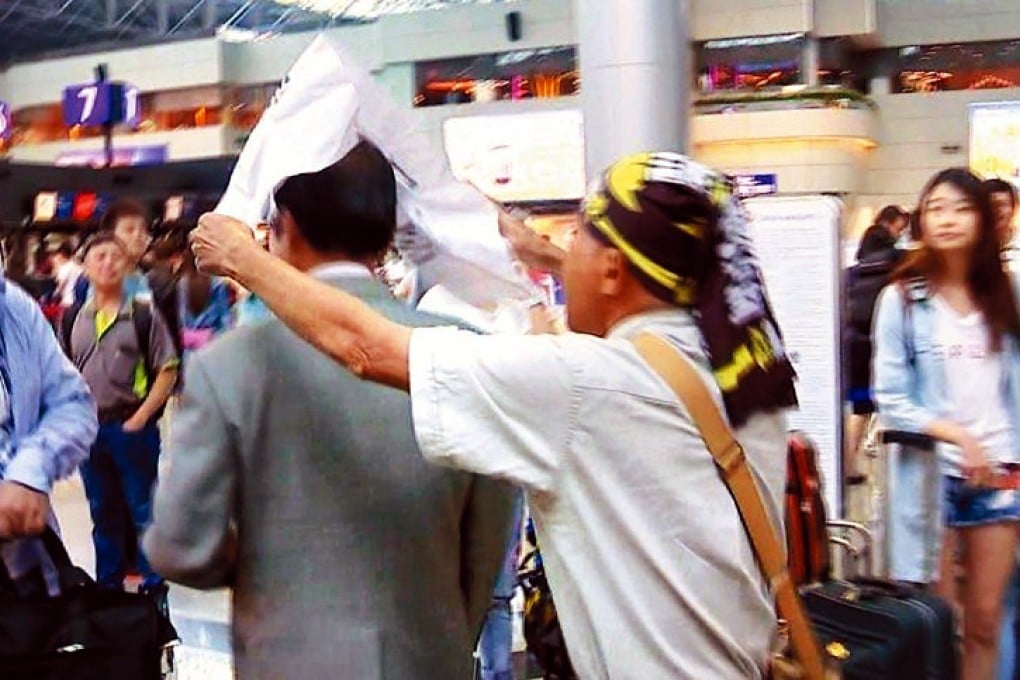 A pro-independence demonstrator mocks Chang Jung-kung, spokesman for former KMT chief Lien Chan, as he addresses journalists yesterday in Taipei. Photo: United Daily News