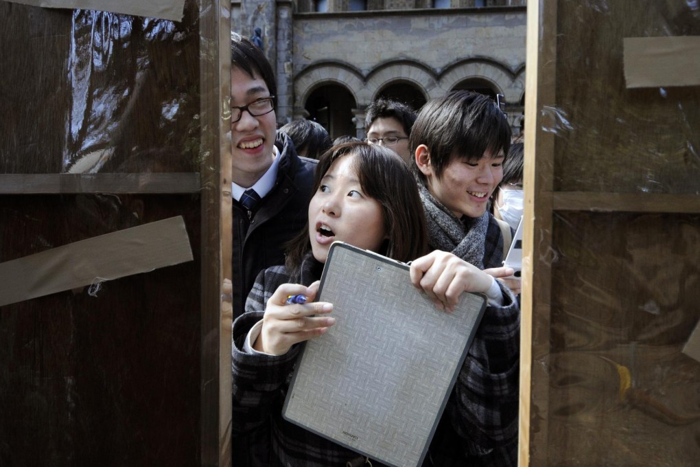 Students check whether they have won a place in Tokyo University. Photo: EPA