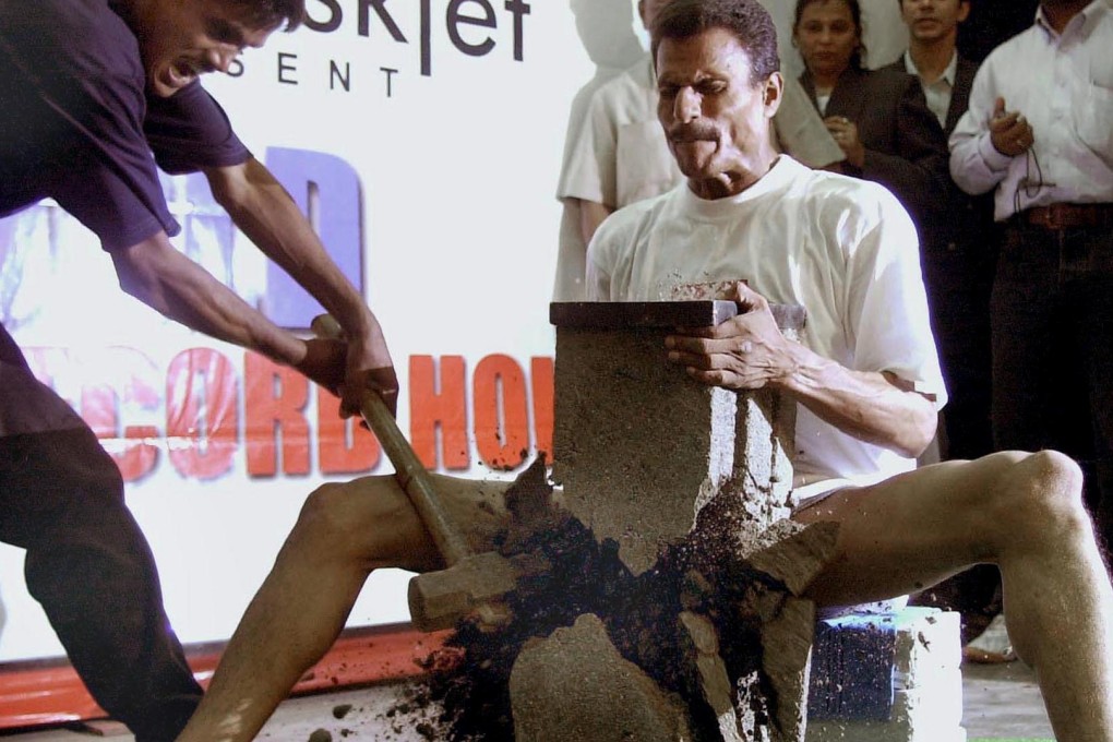 Bibhuti Bhushan Nayak in 2002, setting the Guinness world record for most number of cement blocks broken on the groin. Photo: AFP