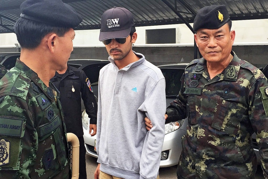 Royal Thai Army soldiers escort the Erawan Shrine bombing suspect after they arrested him in Sa Kaeo district, near the Thai-Cambodian border on Tuesday.  Local media said the suspect was being flown back to Bangkok by helicopter to be interrogated by authorities. Photo: EPA