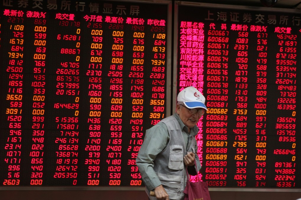 A Chinese investor stands in front of board showing stock prices in the country's gyrating markets. Photo: EPA