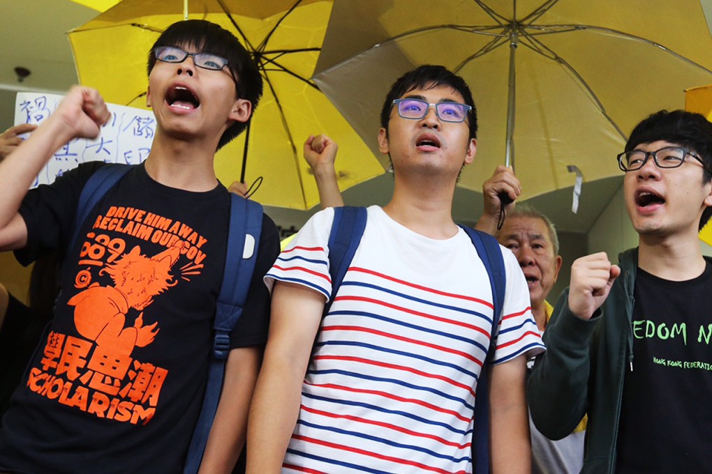 Joshua Wong, Alex Chow and Nathan Law chant slogans outside Eastern Court on Wednesday. Photo: Dickson Lee