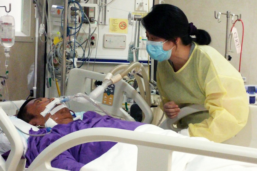Stephen Lee''s wife at his bedside. Photo: SCMP Pictures