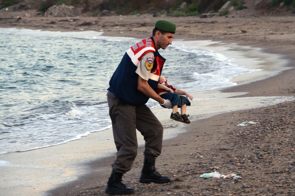 A paramilitary police officer carries the lifeless body of Aylan Kurdi, whose brother and mother also died when their boat sank off Turkey. Photo: AP